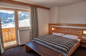 a bedroom with a bed and a large window at Apart Sattelkopf in Fiss