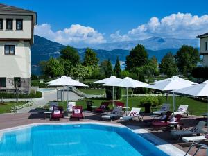 uma piscina com espreguiçadeiras e guarda-sóis em Hotel Du Lac Congress Center & Spa em Ioannina