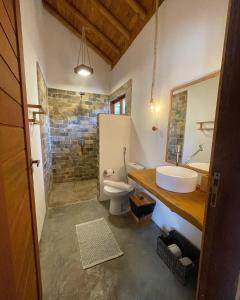 a bathroom with a sink and a toilet at Casa Rosa Atins in Atins