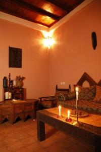 a living room with a couch and candles on a table at DAR OUZOUD Vegan in Ouzoud