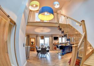 a living room with a staircase and a dining room at Feathered Nest in Hornby