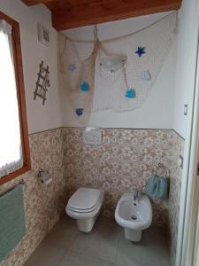 uma casa de banho com um WC e um lavatório em Costalaguna Briccola con 3 camere da letto em Cavallino-Treporti
