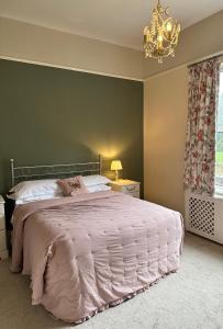 a bedroom with a large bed and a chandelier at Coundon Lodge Coventry in Coventry