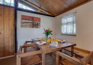 ein Esszimmer mit einem Holztisch und Stühlen in der Unterkunft Birch Lodge in Thornton Watlass