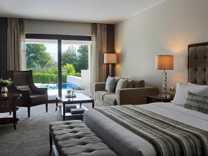a hotel room with a large bed and a living room at Hotel Du Lac Congress Center & Spa in Ioannina