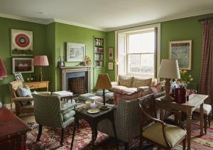 a living room with green walls and a fireplace at North Farm in Walworth