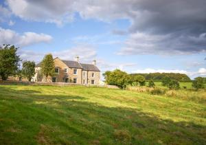 una grande casa su una collina erbosa con un campo di North Farm a Walworth