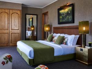 a hotel room with a large bed with white sheets at Hotel Du Lac Congress Center & Spa in Ioannina