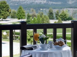 a table with a white table cloth and a glass of wine at Hotel Du Lac Congress Center & Spa in Ioannina