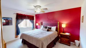 a red bedroom with a bed and a ceiling fan at Adventure Villa #3282 in Moab