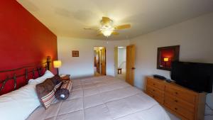 a bedroom with a large bed and a flat screen tv at Adventure Villa #3282 in Moab