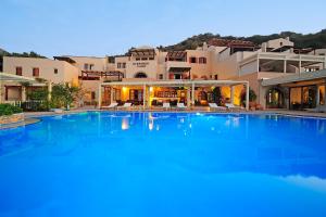 a large swimming pool in front of a building at Stefanos Village Hotel in Plakias