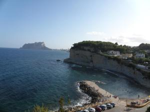 a beach with a group of umbrellas and the ocean at Apartamento Migdia-Moraira in Moraira