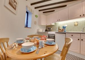 a kitchen with a wooden table with dishes on it at The Old Windmill in Kirkbymoorside