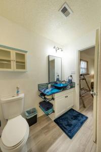a bathroom with a toilet and a blue sink at Keepin' It Salty! in Surfside Beach