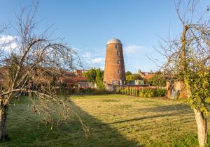 a building with a tower in the middle of a field at The Old Windmill in Kirkbymoorside