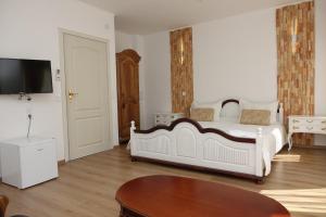 a bedroom with a large white bed and a table at Стаи за гости RADEA in Devin