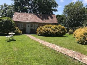 una antigua casa de piedra con una mesa y una mesa de picnic en The Piggery, a perfect country hideaway, en Crowhurst