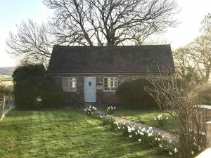 una pequeña casa de ladrillo rojo con puerta blanca en The Piggery, a perfect country hideaway, en Crowhurst