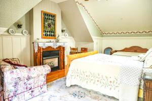 1 dormitorio con 1 cama y chimenea en The Old St Angela Inn en Pacific Grove