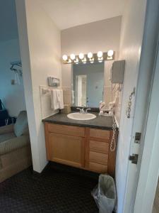 y baño con lavabo y espejo. en Colonial Brick Inn & Suites en Susquehanna