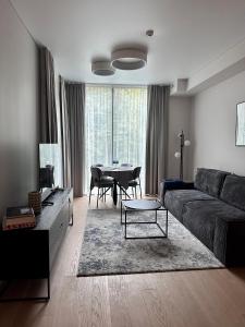 a living room with a couch and a table at Naujai įrengti pušyno apartamentai - bekontaktis įėjimas in Birštonas