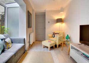 een woonkamer met een bank en een tv bij Maisies Place in Brighton & Hove