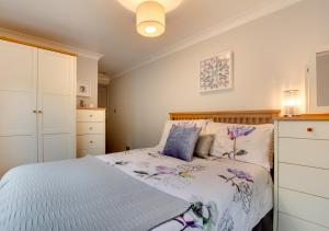 a bedroom with a bed and a white cabinet at Maisies Place in Brighton & Hove