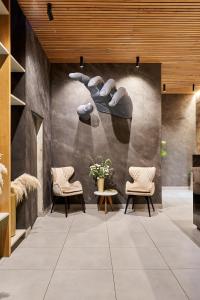 a lobby with two chairs and a table and a wall at Eutopiq Hotel in Medellín
