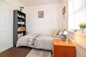 Un dormitorio con una cama y una mesa. en Lovely and Modern Three Bedroom House in Durham en Durham