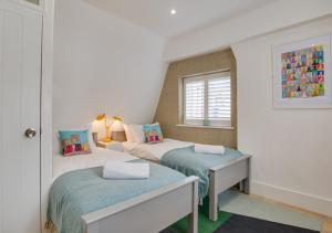 een slaapkamer met 2 bedden en een raam bij Corner Cottage in Brighton & Hove