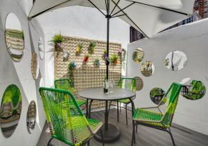 een tafel en stoelen op een patio met een parasol bij Corner Cottage in Brighton & Hove