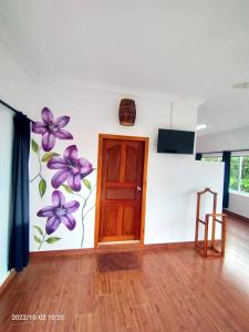 a room with a door and a wall with purple flowers at Atmaland Resort in Kep