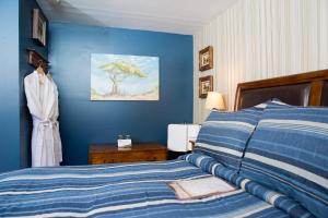 1 dormitorio con cama y pared azul en Maison Des Jardins B & B en Montreal