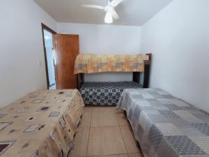um quarto com 2 camas e uma ventoinha de tecto em Casa de temporada Guarapari Casa Dule em Guarapari