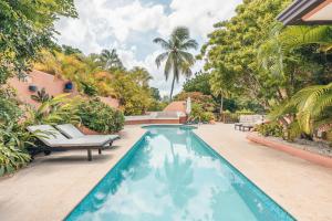 a swimming pool in the backyard of a house at Fun in the sun classic villa at Los Lagos in Casa de Campo in Las Minas