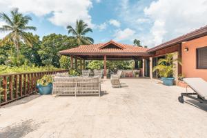 an outdoor patio with chairs and a gazebo at Fun in the sun classic villa at Los Lagos in Casa de Campo in Las Minas