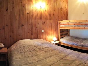 ein Schlafzimmer mit zwei Etagenbetten und Holzwänden in der Unterkunft 2 Pièces 6 Pers Sud à 150m des Pistes - FR-1-416-4 in La Toussuire