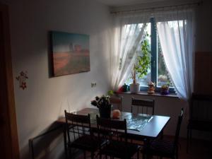 comedor con mesa, sillas y ventana en Gästezimmer Ferienwohnung VILLA ALEXA, mit Wallbox, en Woltersdorf