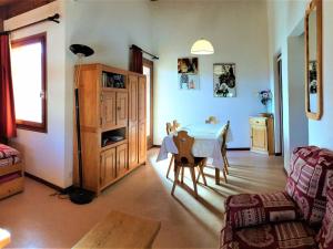 ein Wohnzimmer mit einem Tisch und einem Stuhl in der Unterkunft Appart 8 pers à 150m des pistes, 2 chambres - FR-1-416-34 in La Toussuire