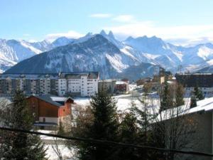 eine Stadt mit schneebedeckten Bergen im Hintergrund in der Unterkunft Appart 8 pers à 150m des pistes, 2 chambres - FR-1-416-34 in La Toussuire + 3 Fotos