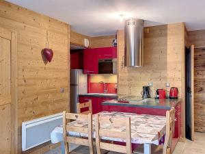 ラ・トゥッスイールにあるAppartement La Toussuire, 4 pièces, 6 personnes - FR-1-416-35のキッチン(赤いキャビネット、テーブル、椅子付)