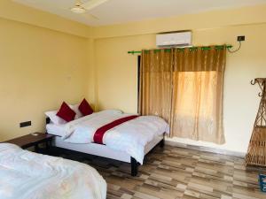 1 dormitorio con 2 camas y ventana en Hotel Happy Land, en Chitwan