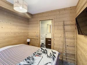 a bedroom with wooden walls and a bed in it at Appartement lumineux 3 chambres, parking privé, au pied des pistes - FR-1-416-87 in La Toussuire