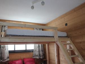 een slaapkamer met 2 stapelbedden in een blokhut bij Appartement lumineux 6 pers, 2 ch, départ ski au pied - FR-1-416-94 in La Toussuire