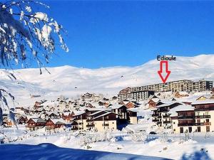 een stad bedekt met sneeuw met een gebouw op de achtergrond bij Appartement lumineux 6 pers, 2 ch, départ ski au pied - FR-1-416-94 in La Toussuire