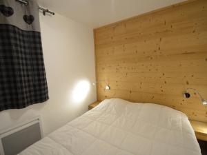 レ・メニュアールにあるAppartement Les Menuires, 3 pièces, 6 personnes - FR-1-452-1の木製の壁のドミトリールームのベッド1台分です。