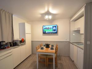 a kitchen with a table and a tv on the wall at Studio Les Menuires, 1 pièce, 4 personnes - FR-1-452-2 in Les Menuires