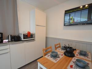 a kitchen with a table and chairs and a microwave at Studio Les Menuires, 1 pièce, 4 personnes - FR-1-452-2 in Les Menuires