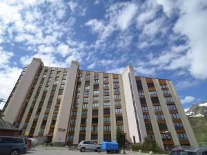 a large building with cars parked in a parking lot at Studio lumineux avec balcon, au pied des pistes, Les Menuires – 3 personnes - FR-1-452-17 in Les Menuires